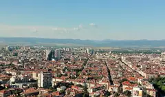 Покривите на жилищни и обществени сгради в центъра на София, а в далечината – планина